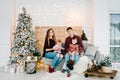 Merry Christmas. Happy mother, father and kids near Christmas tree indoors. Beautiful young family enjoying their holiday time Royalty Free Stock Photo