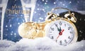 Merry Christmas and Happy New Year background with text. Golden alarm clock in snowdrifts, champagne bottle and glasses on blue Royalty Free Stock Photo