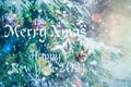 Merry Christmas and Happy New Year 2021! Blurred background of Christmas tree in snowfall decorated with silver balls, lights. Royalty Free Stock Photo