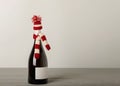 Merry Christmas and a Happy New Year! Bottle of wine in a knitted cap of Santa Claus. Royalty Free Stock Photo