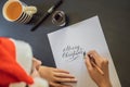 Merry christmas and a happy new year. Calligrapher Young Woman writes phrase on white paper. Inscribing ornamental Royalty Free Stock Photo