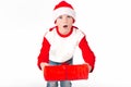 Merry christmas. Happy New Year. Caucasian young schoolboy in Santa costume holds a red Christmas box