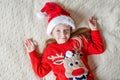 Merry Christmas and Happy new year. Cheerful little caucasian girl six years old on bed. Stay at home during coronavirus Royalty Free Stock Photo