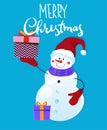 Merry Christmas and Happy New Year. Cheerful snowman with gifts and in a Santa hat on a blue background with the inscription. Royalty Free Stock Photo