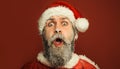 Merry Christmas. Happy New Year. Closeup portrait amazed bearded man in Santa costume and Santa hat. Winter holidays