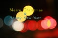 Merry Christmas and Happy New Year. With colorful bokeh light on black background. Christmas and New Year text design concept in Royalty Free Stock Photo