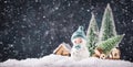 Merry Christmas and happy New Year composition with copy space. Little snowman carries Christmas tree from fairy forest to home. Royalty Free Stock Photo