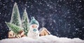 Merry Christmas and happy New Year composition with copy space. Little snowman carries Christmas tree from fairy forest to home. Royalty Free Stock Photo