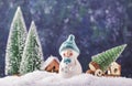 Merry Christmas and happy New Year composition with copy space. Little snowman carries Christmas tree from fairy forest to home. Royalty Free Stock Photo