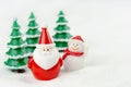 Merry Christmas and happy new year concept. Cute santa claus figure and tree on snow with copy space