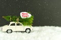 Merry Christmas Happy New Year concept. Retro toy car with christmas tree on snowy winter background. Copy space for your text Royalty Free Stock Photo