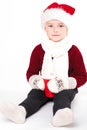 Merry Christmas and happy New year! Cute happy little boy holding red cup. Kid enjoy holiday santa hat. Portrait kid on light Royalty Free Stock Photo