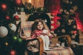 Merry christmas and happy new year. Cute little child girl play near christmas tree. Kid enjoy winter holiday at home Royalty Free Stock Photo