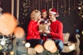 Merry Christmas and Happy New Year! Family gives present box to baby in living room decorated by christmas tree and xmas gift Royalty Free Stock Photo