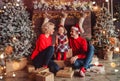 Merry Christmas and Happy New Year! Family gives present box to baby in living room decorated by christmas tree and xmas gift Royalty Free Stock Photo