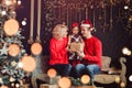 Merry Christmas and Happy New Year! Family gives present box to baby in living room decorated by christmas tree and xmas gift Royalty Free Stock Photo