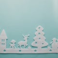 Merry Christmas and Happy New Year. Foam cutter of City with reindeers and snow boy, art and craft style on pastel color paper Royalty Free Stock Photo