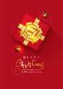 Merry Christmas and Happy New year. Gift box tied gold bow decorated with Christmas balls, golden confetti, on red background. Royalty Free Stock Photo