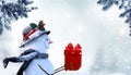 Merry Christmas and happy New Year greeting card with copy-space. Happy snowman with red gift box standing in Christmas Royalty Free Stock Photo