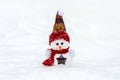 Merry christmas and happy new year greeting card with copy space Happy little snowman in red cap and scarf standing in winter snow Royalty Free Stock Photo