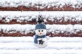 Merry christmas and happy new year greeting card with copy space Happy little snowman in red cap and scarf standing in winter snow Royalty Free Stock Photo