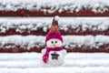 Merry christmas and happy new year greeting card with copy space Happy little snowman in red cap and scarf standing in winter snow Royalty Free Stock Photo