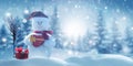 Merry Christmas and happy New Year greeting card with copy-space. Happy snowman with red gift box standing in Christmas Royalty Free Stock Photo