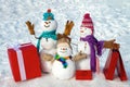 Merry Christmas and happy New Year greeting card. Snowmans in winter Christmas landscape. Snowman family with gifts and