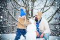 Merry Christmas and Happy New Year. Happy father and son making snowman in the snow. Handmade funny snow man. Family Royalty Free Stock Photo