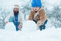 Merry Christmas and Happy New Year. Happy father and son making snowman in the snow. Handmade funny snow man. Royalty Free Stock Photo