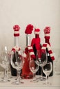 Merry Christmas and Happy New Year! Holiday knitted decor - Santa Claus knitted hats on the bottle with wine. Royalty Free Stock Photo