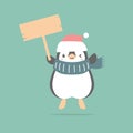 merry christmas and happy new year with penguin holding blank sign in the winter season green background Royalty Free Stock Photo