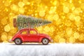 Merry Christmas and Happy New Year Postcard or Poster. Little classic red car carrying Christmas tree on its rack on the