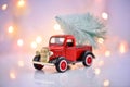 Merry Christmas and Happy New Year Postcard. Retro pickup truck with christmas tree on a festive background