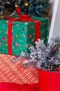 Merry Christmas and Happy New Year presents standing under the decorated fir-tree with red bulbs, toys and bows. Winter holidays Royalty Free Stock Photo