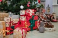 Merry Christmas and Happy New Year presents standing under the decorated fir-tree with red bulbs, toys and bows. Royalty Free Stock Photo