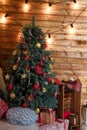 Merry Christmas and Happy New Year presents standing under the decorated fir-tree with red bulbs, toys and bows. Winter holidays Royalty Free Stock Photo