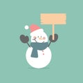 merry christmas and happy new year with snowman holding blank sign in the winter season green background Royalty Free Stock Photo