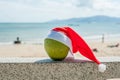 Merry Christmas and Happy New Year on the summer beach. Coconut in santa hat. Palms and blue sky on the background Royalty Free Stock Photo