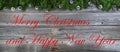 Merry Christmas and Happy New Year theme with fir branches plus pinecone ornaments on rustic wood Royalty Free Stock Photo