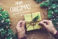 MERRY CHRISTMAS AND HAPPY NEW YEAR typography,text with human hand decorating gift box presents