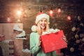 Merry Christmas and Happy New Year. Woman with christmas present boxes in front of christmas tree. Home Holiday. Winter Royalty Free Stock Photo