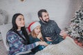 Merry Christmas and Happy New Year . Young family celebrating holiday at home. The Father is holding the remote from the Royalty Free Stock Photo
