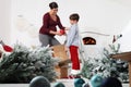 Merry christmas, happy pregnant woman and her child prepare the Christmas tree, open the boxes of balls decorations in the living