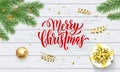 Merry Christmas holiday golden decoration on Xmas tree, calligraphy font for greeting card on white wooden background. Vector Chri Royalty Free Stock Photo