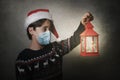 Merry Christmas,kid with medical mask holding an old lantern