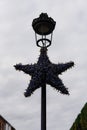 merry christmas. Christmas light star hanging on a street lamp