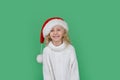 Merry Christmas Little girl in Santa hat on bright green vivid color background Royalty Free Stock Photo