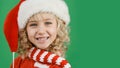 Merry Christmas Little girl in Santa hat on bright green vivid color background Royalty Free Stock Photo