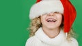 Merry Christmas Little girl in Santa hat on bright green vivid color background Royalty Free Stock Photo